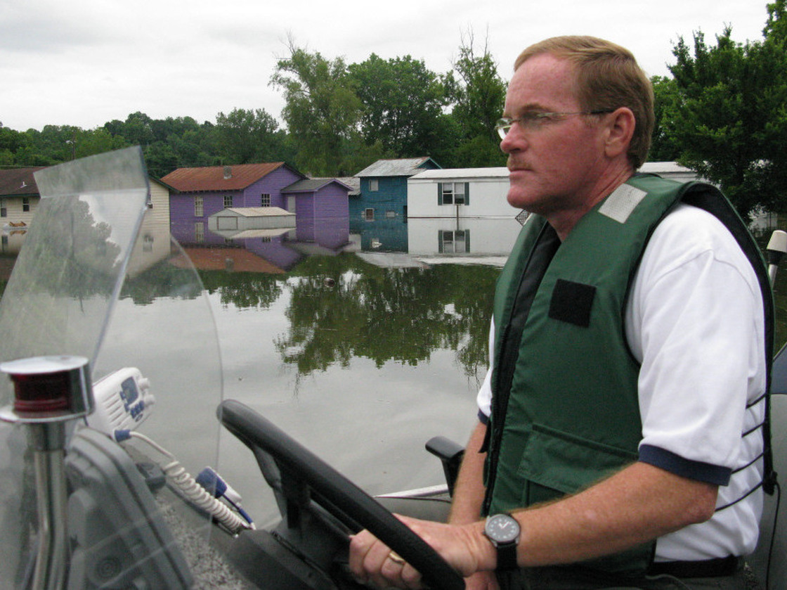 Warren County, Miss., Sheriff Martin Pace steers his small  boat through a flooded neighborhood in Vicksburg.