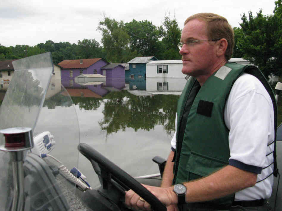 Warren County, Miss., Sheriff Martin Pace steers his small  boat through a flooded neighborhood in Vicksburg.