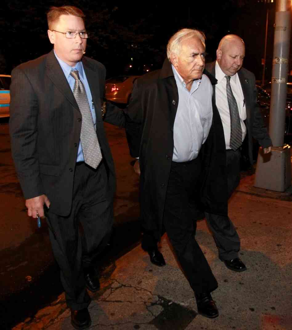 International Monetary Fund leader Dominique Strauss-Kahn (center) is led into court early Monday in New York.
