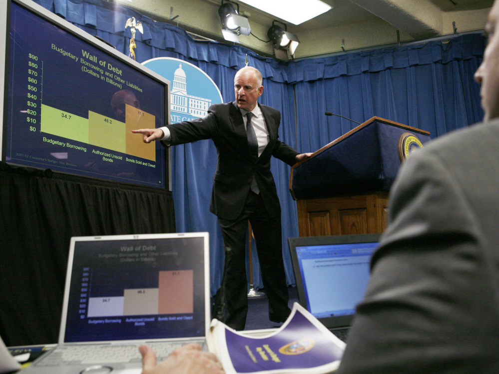 Gov. Jerry Brown points to a chart at a news conference at the Capitol in Sacramento, Calif.