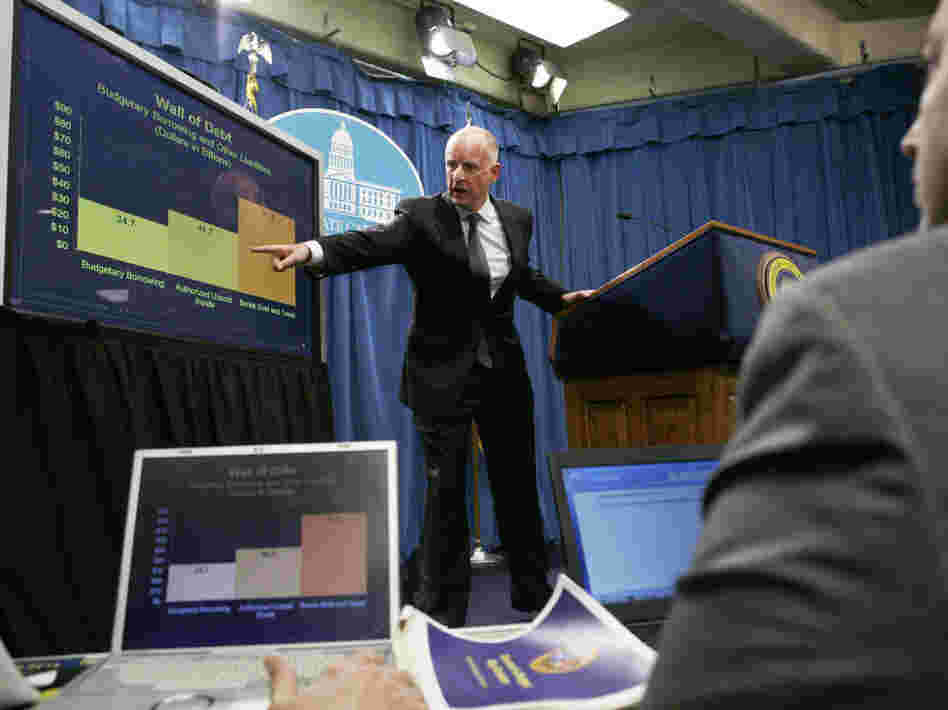 Gov. Jerry Brown points to a chart at a news conference at the Capitol in Sacramento, Calif.