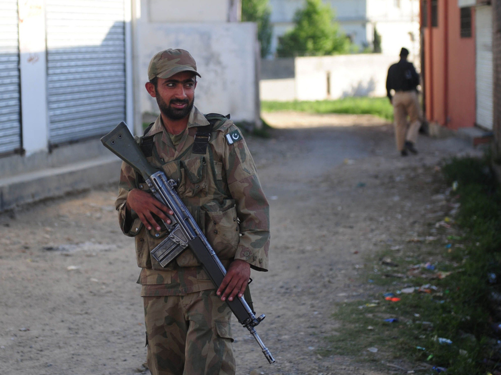 Pakistani military and police officials cordoned off a street in Abbottabad near the compound where Osama Bin Laden was found and killed. (May 8, 2011, file photo.)