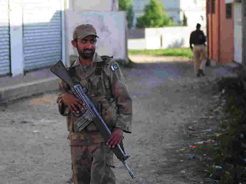 Pakistani military and police officials cordoned off a street in Abbottabad near the compound where Osama Bin Laden was found and killed. (May 8, 2011, file photo.)