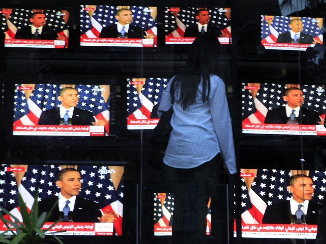 An Egyptian woman watches President Obama's policy address, outside a shop selling televisions in Cairo on Thursday.