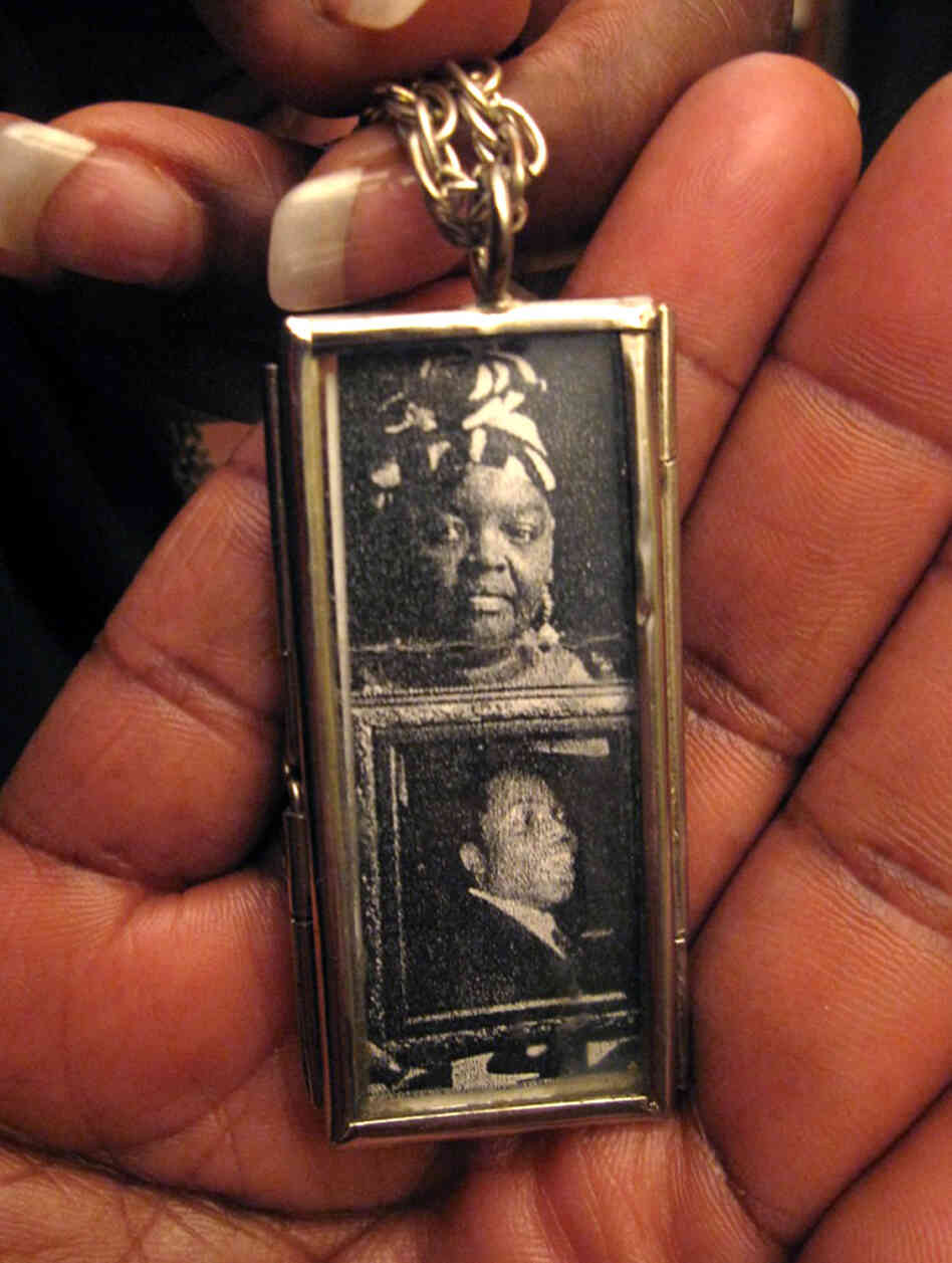 Mary Johnson holds a two-sided locket she wears on a necklace. On one side are photos of herself and her son; the other has a picture of Oshea Israel.