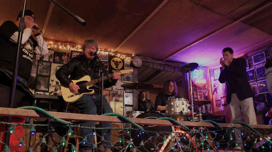 A warm-up band at Gip's Place features a rookie harmonica player.