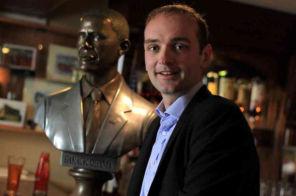 An eighth-cousin of Obama, Henry Healy, poses with a bust of the president in Ollie Hayes Pub. 