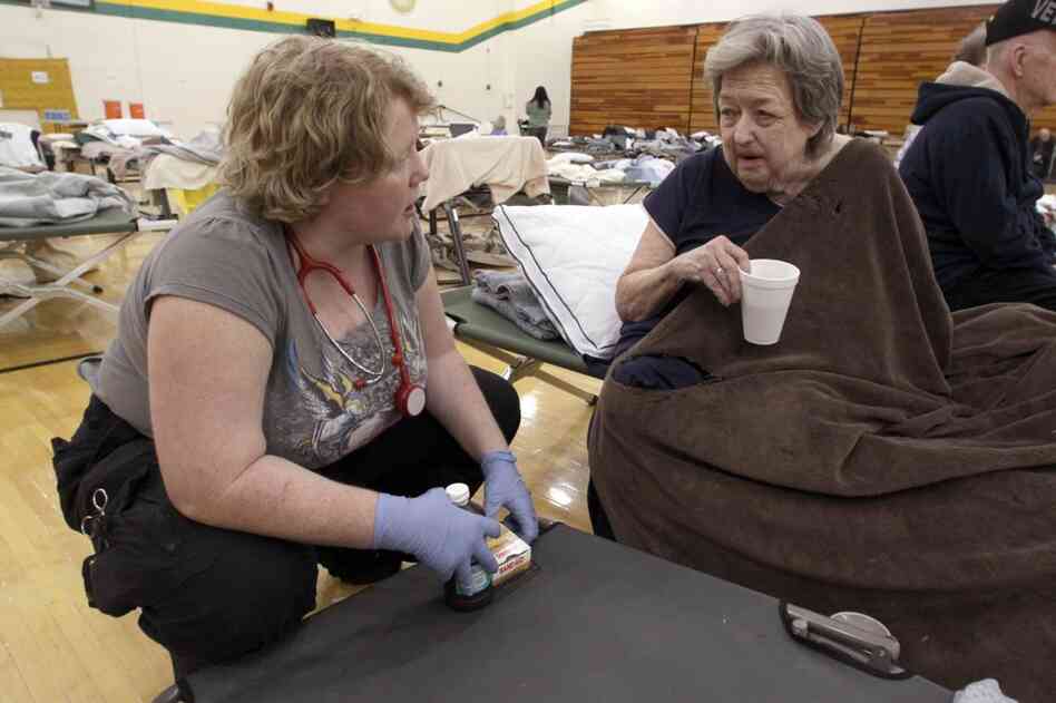 Delma Boyd of Joplin, Mo., (right) talks with medical technician Angela O'Leary of Purdy, Mo., in a temporary American Red Cross shelter at Missouri Southern State University in Joplin. 