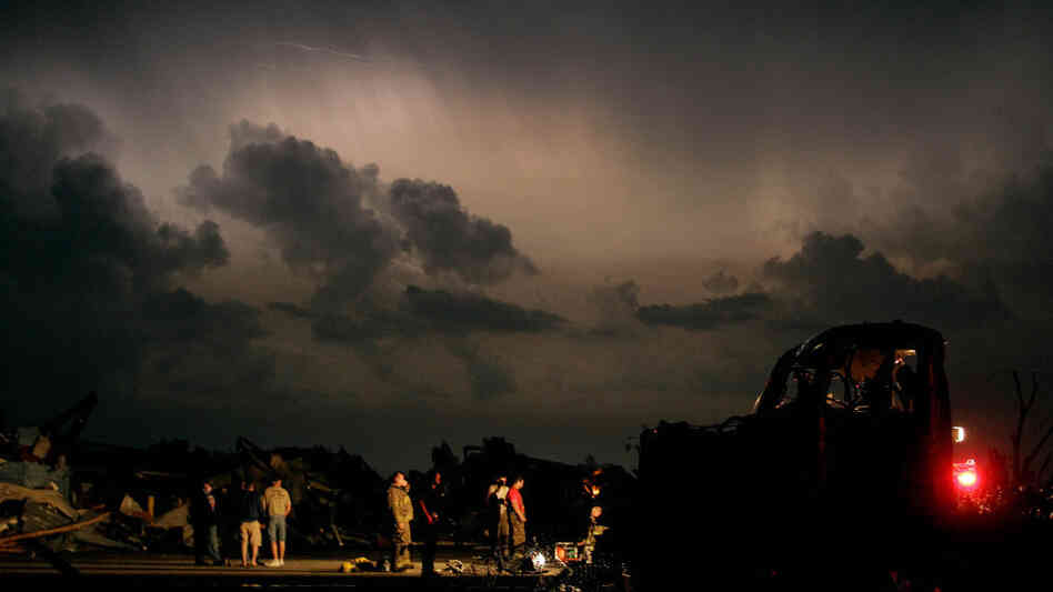 Emergency workers wait for a medical team after finding a body in a tornado-ravaged car in Joplin, Mo., earlier today (May 23, 2011).