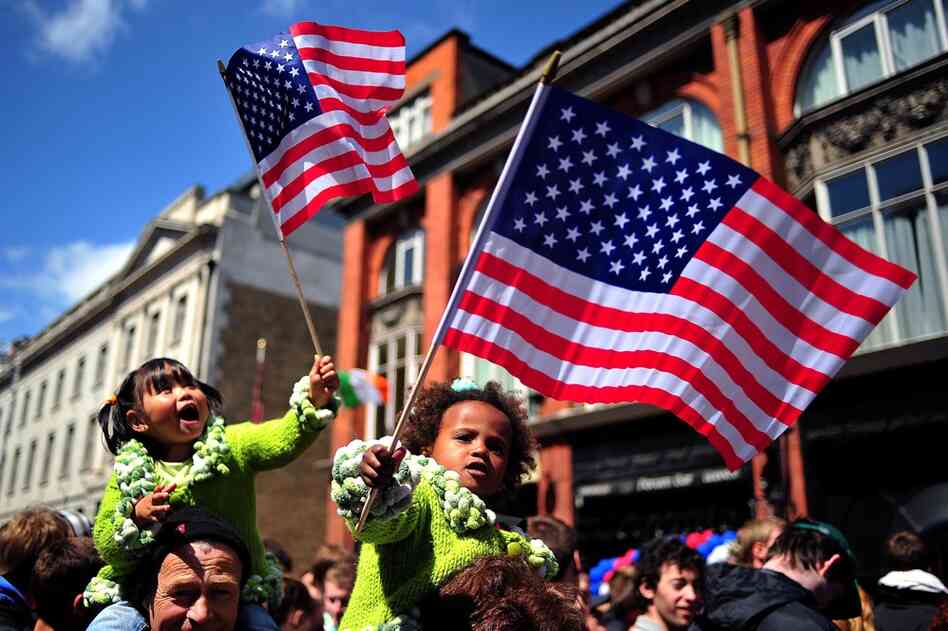 Children wave U.S. flags as they wait to see Obama address a rally at College Green in Dublin. 