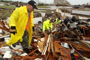 Tom Cravens of the Pryor, Okla., Police Department looks through the rubble of a destroyed home near the St. John's Regional Medical Center in Joplin, Mo.