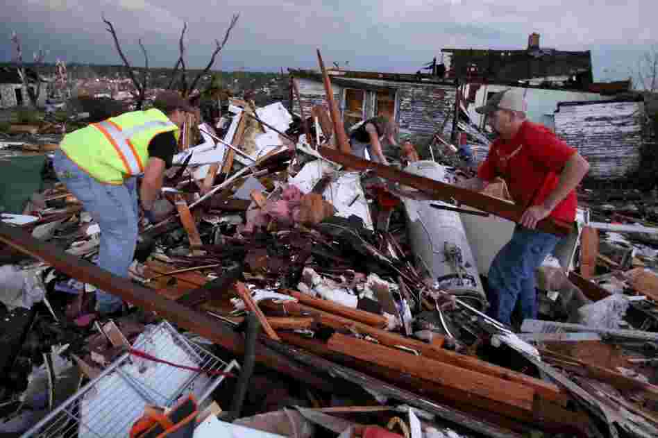 Volunteer firefighters William Jackson (from left) and Ashley Martin of Oklahoma and Johnny Ward of Joplin look through the wreckage of a home where it was feared a pregnant woman was trapped. 