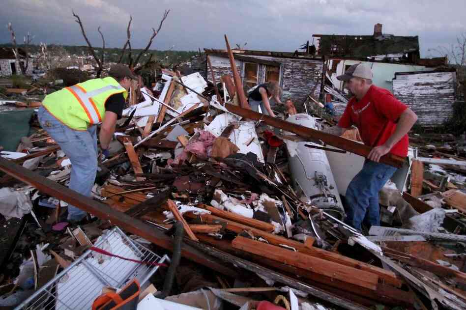 Volunteer firefighters William Jackson (from left) and Ashley Martin of Oklahoma and Johnny Ward of Joplin look through the wreckage of a home where it was feared a pregnant woman was trapped. 