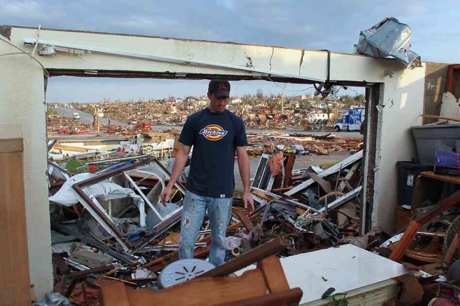 Mark Hootselle helps a friend salvage what they can from a destroyed house. 