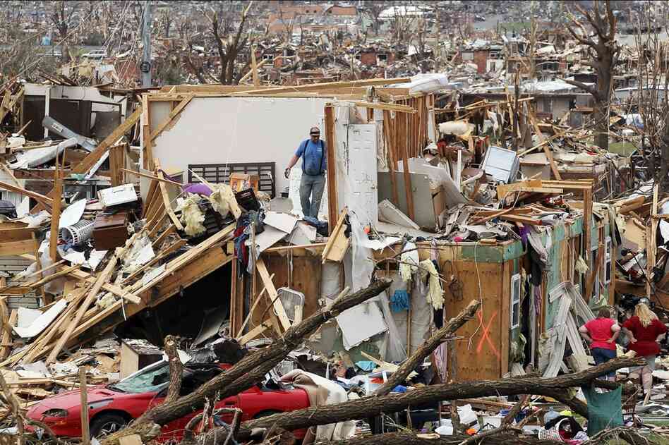 People try to salvage items from the Albrecht family home on Tuesday in Joplin, Mo. 