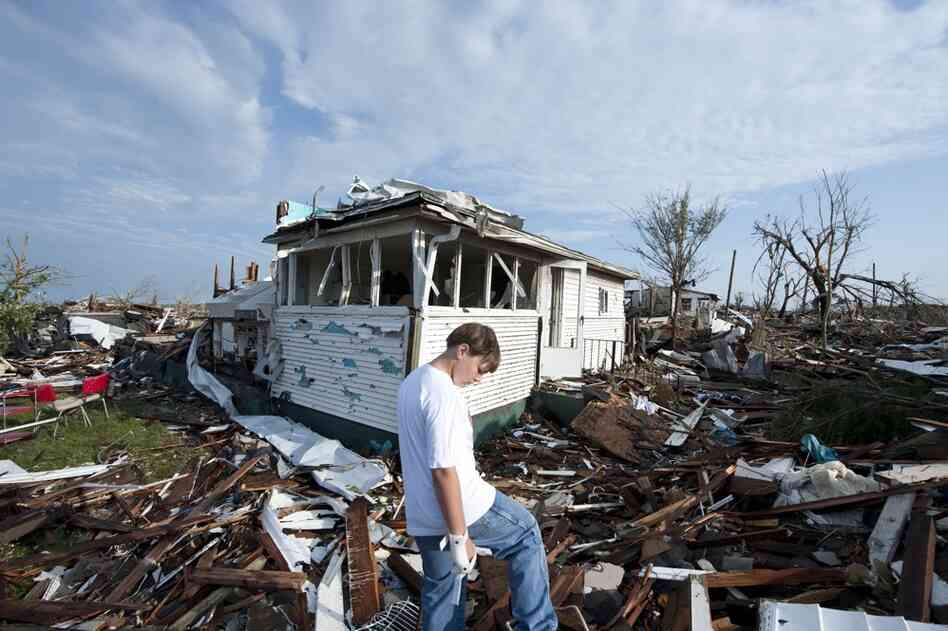 Tucker Scott looks for his pet cat in the rubble of the home where he lived with his mother. 