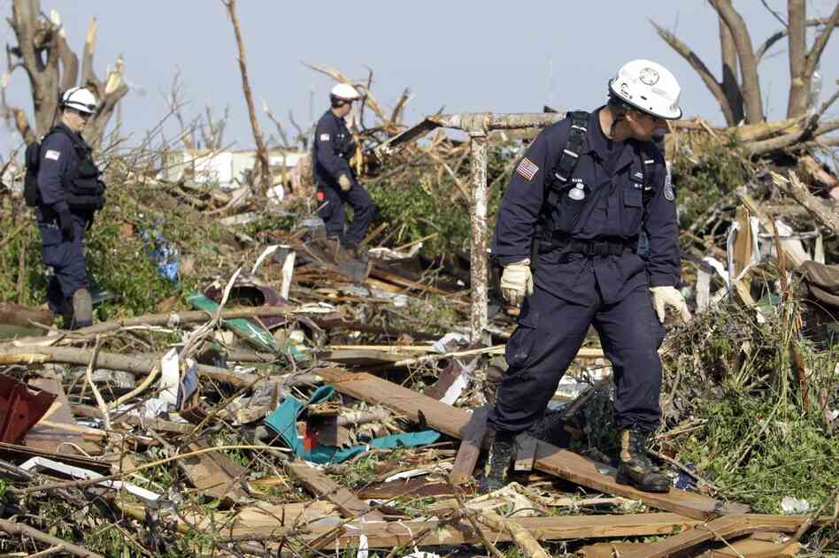 Oklahoma Task Force One search-and-rescue members, from left, Jim Winham, Nick Swainston and Kevin Mann search through debris for victims. 