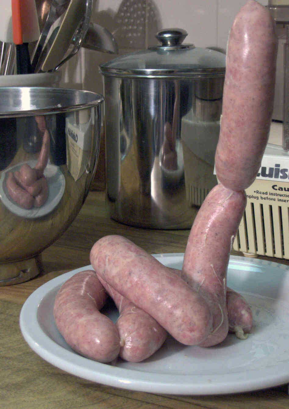Links of homemade sausage extruded from a stand mixer with grinding and stuffing attachments. Links of homemade sausage extruded from a stand mixer with grinding and stuffing attachments.