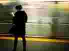 A commuter reads while as her train arrives. A commuter reads while as her train arrives.