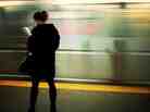 A commuter reads while as her train arrives. A commuter reads while as her train arrives.