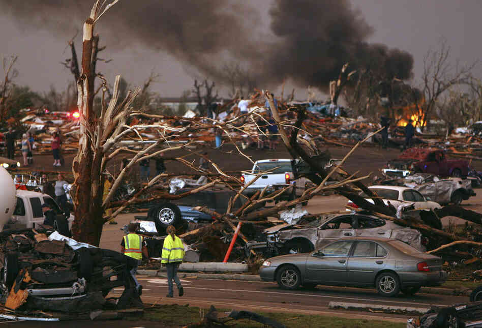 Emergency personnel walk through a neighborhood severely damaged by a tornado near St. John's Regional Medical Center. 