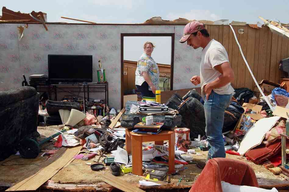 Royn Watkins (right) helps his friend Leann Bobbins salvage what remains of her trailer after it was destroyed when a tornado passed through Denning, Ark. on Tuesday. 