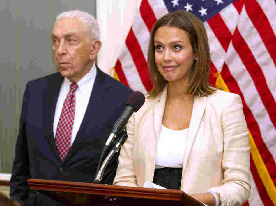 Actor Jessica Alba, accompanied by Sen. Frank Lautenberg (D-NJ), reacts when a buzzer calling for a vote goes off during a news conference on Capitol Hill Tuesday about chemical regulation.