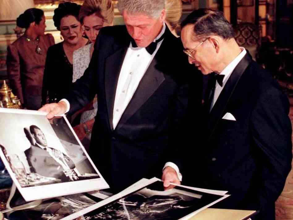 President Clinton shows Thai King Bhumibol Adulyadej photos of famous American jazz musicians as they exchange gifts at Bangkok's Grand Palace on Nov. 26, 1996. President Clinton shows Thai King Bhumibol Adulyadej photos of famous American jazz musicians as they exchange gifts at Bangkok's Grand Palace on Nov. 26, 1996.