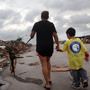 Kimmy Lankford and her 5-year-old son, Jack, walk through their neighborhood Wednesday after a massive tornado passed through the town. The Lankfords continue to live in their home a few blocks away, which was damaged but remains habitable.