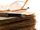 Glasses and a pen rest on a manuscript. Glasses and a pen rest on a manuscript.