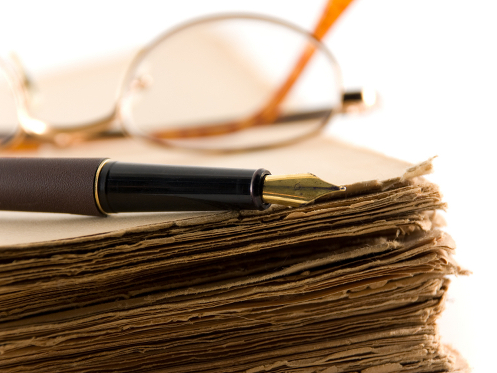 Glasses and a pen rest on a manuscript.