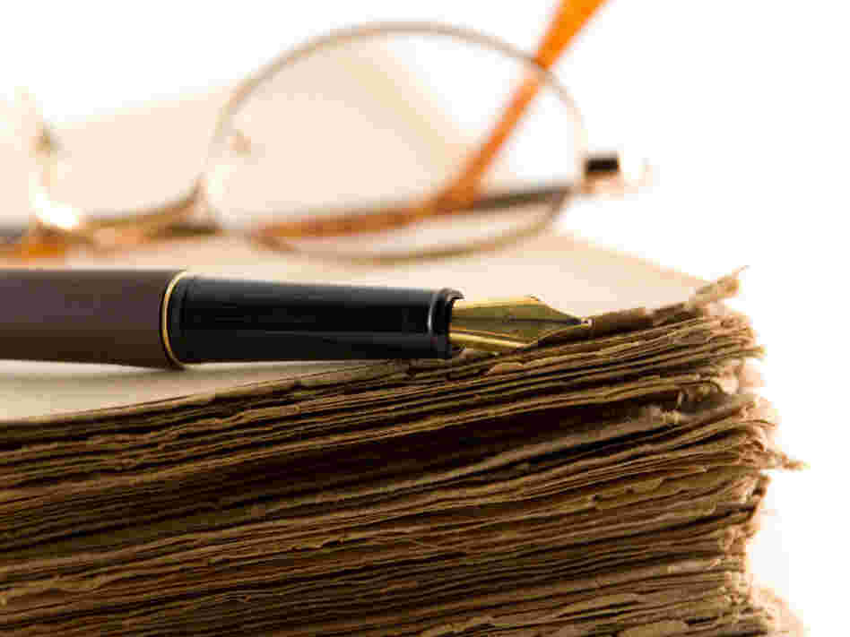 Glasses and a pen rest on a manuscript.