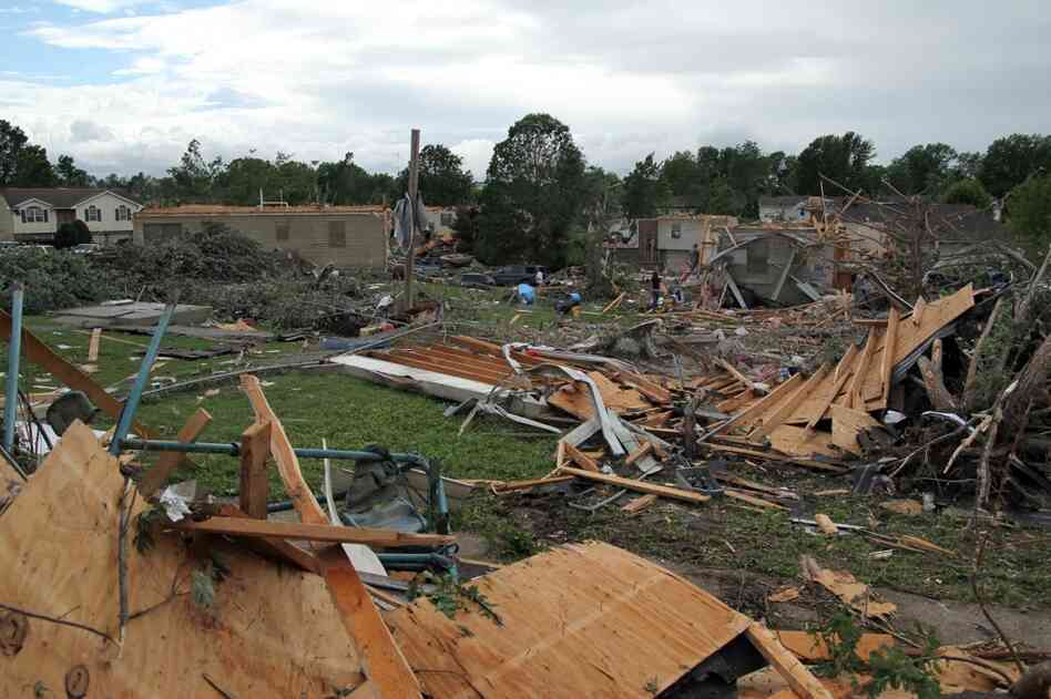 People pick through the debris in the wreckage of homes damaged by a tornado in Sedalia, Mo., on Wednesday. 