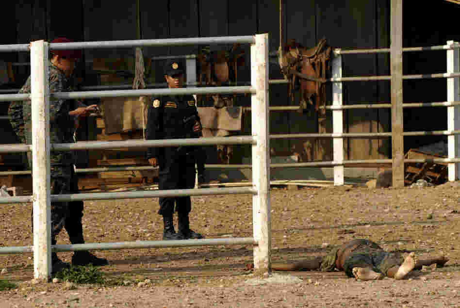 Investigators work at the site of a massacre at a ranch in northern Guatemala. Most of the 27 people killed were decapitated.
