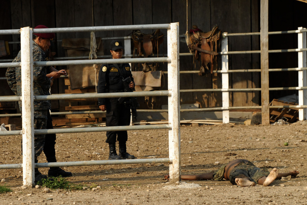 Investigators work at the site of a massacre at a ranch in northern Guatemala. Most of the 27 people killed were decapitated.