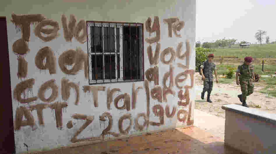 Soldiers walk past part of a message written in blood at the site of a massacre at a ranch in northern Guatemala on May 16. The message is a warning to Otto Salguero — the owner of the ranch, according to local media. Guatemalan authorities blame the killings on the Mexican drug cartel Los Zetas. Soldiers walk past part of a message written in blood at the site of a massacre at a ranch in northern Guatemala on May 16. The message is a warning to Otto Salguero — the owner of the ranch, according to local media. Guatemalan authorities blame the killings on the Mexican drug cartel Los Zetas.