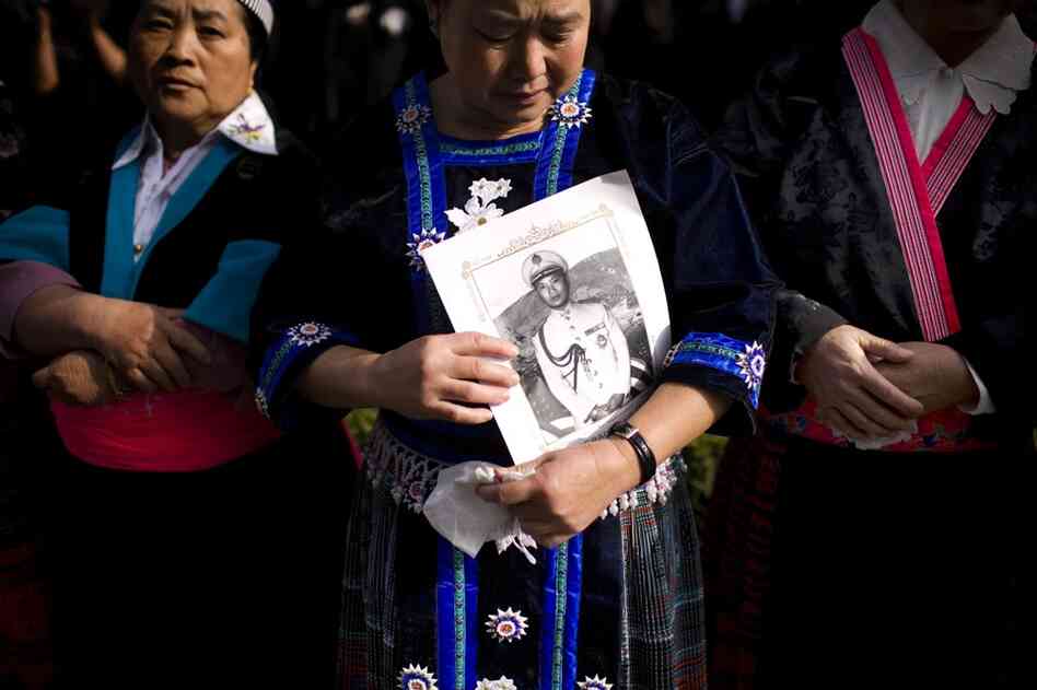 A mourner holds a photo of  Gen. Vang Pao during the funeral procession. Vang was a hero of the Hmong community, and thousands gathered for his six-day long funeral. He died on Jan. 6 at age 81. 