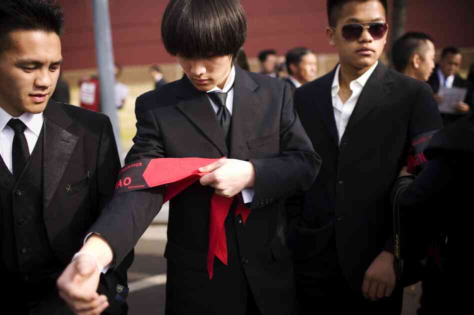 Kingsley Yang ties on an armband during the funeral procession. Members of the general's family had hoped he would be buried in Arlington National Cemetery, but the Pentagon denied the request.