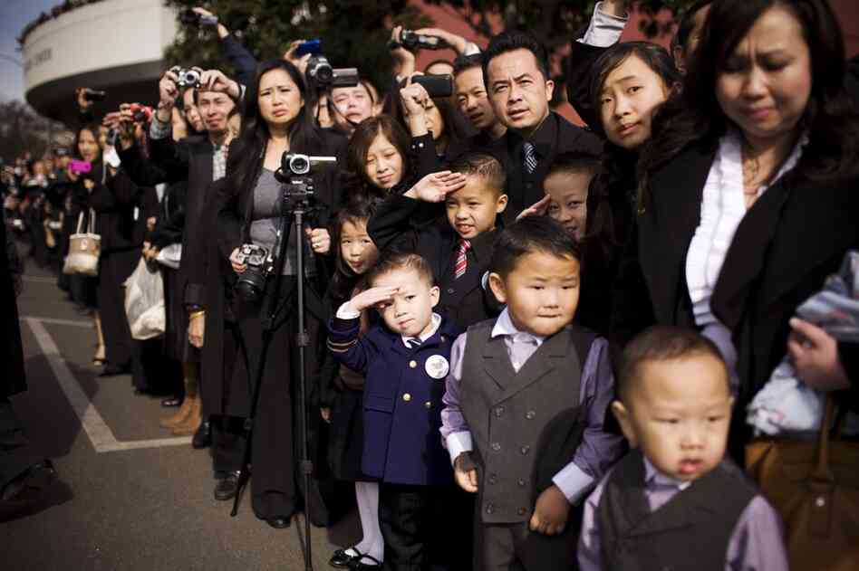 Thousands from the Hmong community line the streets as the general's body is transported on a horse-drawn carriage to Fresno's convention center for the funeral.
