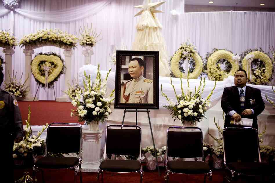 A portrait of Vang sits amidst funeral wreaths at the Fresno Convention Center.
