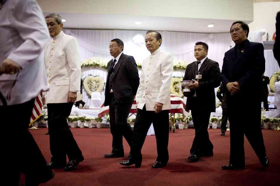 Prince Bouavong Kattygnarath (center) of the Lao royal family passes Vang's casket. Foreign dignitaries, U.S. military officials and elected representatives were among the thousands who came to mourn the general.