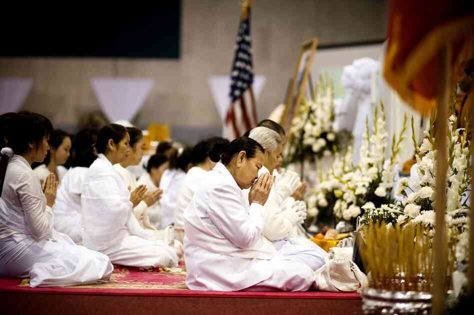 Family members pray during the Buddhist ceremony for Vang. The six-day funeral ended on Feb. 9.