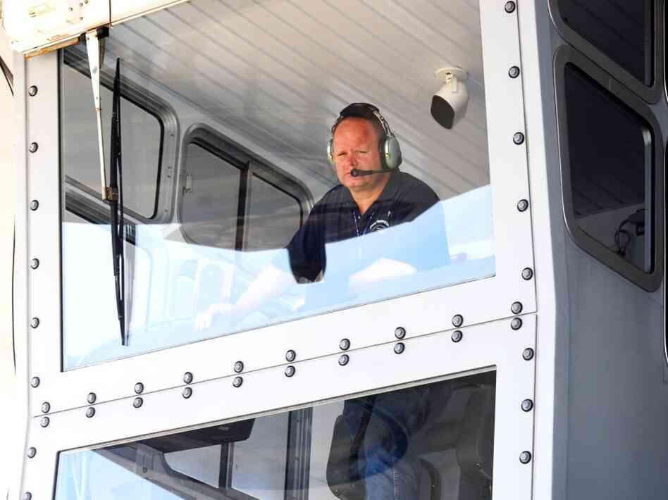 Bill Couch looks down from the cab of the crawler.  Couch is one of only six people certified to drive the enormous machine.