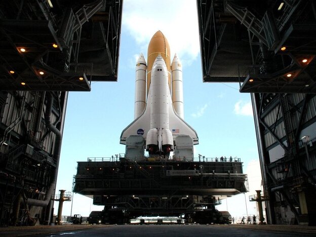 Framed in the doors of the Kennedy Center's Vehicle Assembly Building, the crawler begins the long journey toward Launch Pad 37B with space shuttle Discovery in April 2005.  This enormous cross between a tank and a cargo ship is the largest self-powered land vehicle in the world.