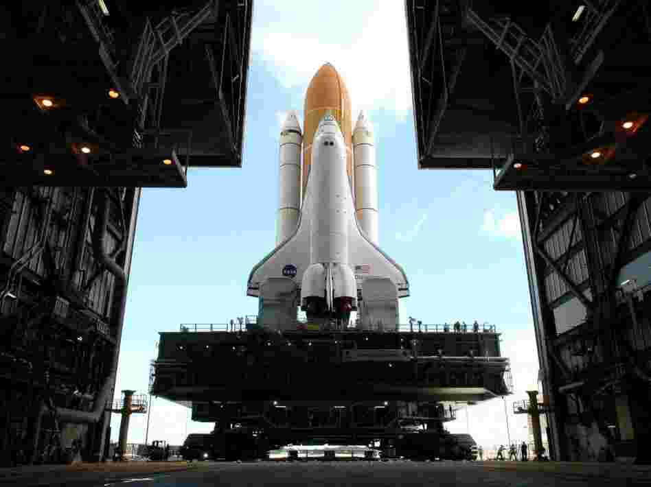 Framed in the doors of the Kennedy Center's Vehicle Assembly Building, the crawler begins the long journey toward Launch Pad 37B with space shuttle Discovery in April 2005.  This enormous cross between a tank and a cargo ship is the largest self-powered land vehicle in the world.