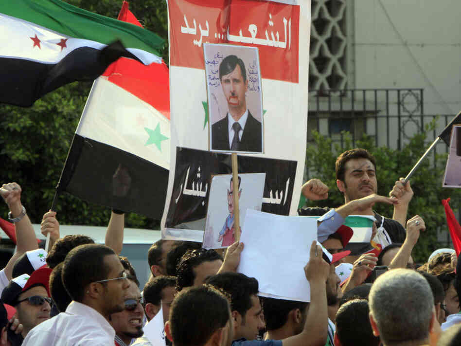 Protesters demand that Syrian President Bashar al-Assad step down, in front of Arab League headquarters in Cairo.