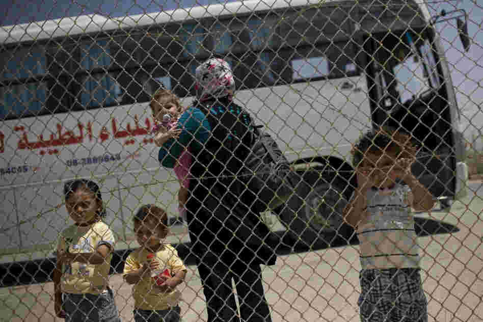 A Palestinian family waits to cross from the Gaza Strip into Egypt through the Rafah border crossing on Saturday.