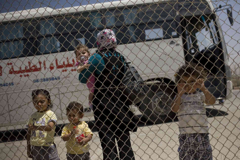 A Palestinian family waits to cross from the Gaza Strip into Egypt through the Rafah border crossing on Saturday.
