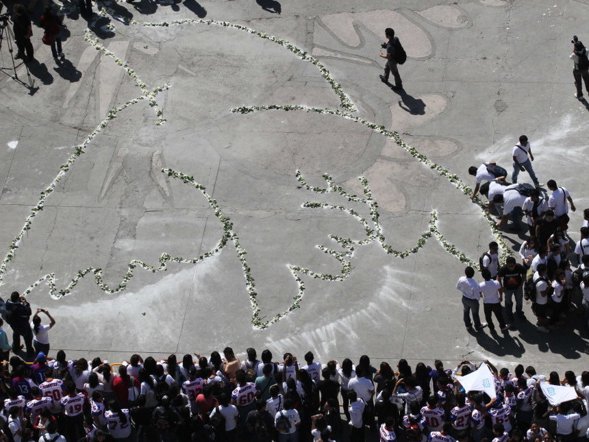 University students gather around a dove drawn with flowers during a demonstration against violence in Monterrey, Mexico, Friday, March 11.