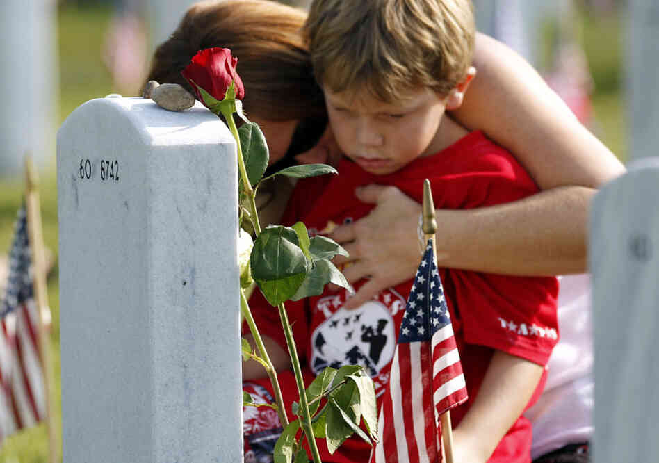 Trisha Lawton and her son, Caden, pray over the grave of husband and father Marine Capt. Garrett T. Lawton on Monday. Trisha Lawton and her son, Caden, pray over the grave of husband and father Marine Capt. Garrett T. Lawton on Monday.